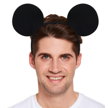 A man wearing a black headband with two large round mouse ears, photographed against a plain white background.
