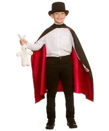 A child wearing a vampire costume with a black top hat, white shirt, black pants, and a black cape with a red lining, holding a small white stuffed bunny against a plain white background.