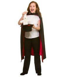 A child modeling a magician costume consisting of a white shirt, black pants, a black cape with red lining, and holding a black top hat with a white rabbit inside, against a plain white background.