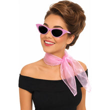 A woman with an elegant updo hairstyle wearing pink cat-eye sunglasses with a sheer pink scarf tied around her neck and a black off-the-shoulder top, set against a solid white background.