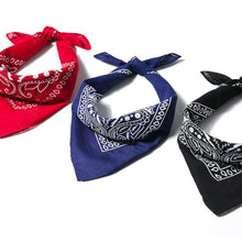 Three bandana neckties with white paisley patterns shown on a white background: red with white, navy blue with white, and black with white.
