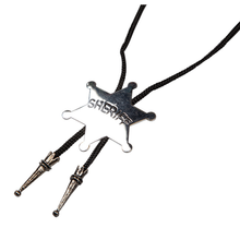 A silver sheriff's badge bolo tie necklace with a black braided cord and silver-toned conical ties, shown on a plain white background.