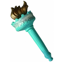 A decorative liberty inspired torch with a turquoise handle, a metallic gold flame-like top, and a turquoise ornate collar, shown on a plain white background.