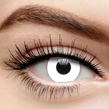 Close-up of a person's eye with white contact lenses and long, thick eyelashes.
