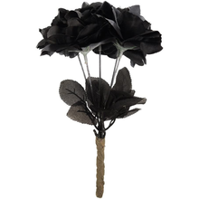 Artificial black roses with layered black petals, dark leaves, and a twisted natural-fiber looking stem on a plain white background.