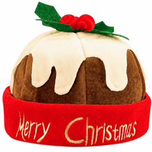 A plush Christmas pudding hat with brown fabric, cream icing, green holly leaves, and red berries on top, plus a red brim embroidered with 'Merry Christmas' in gold.