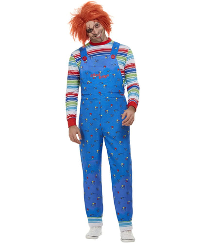 A person modeling a Chucky costume consisting of blue overalls with a small red and yellow print, a rainbow-striped long-sleeve shirt, and a bright orange wig, shown against a plain white background.