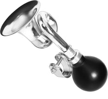 Metallic clown horn with black spherical button on a white background