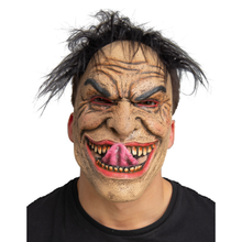A person wearing a creepy, distorted monster mask with wild black hair, red eyes, and an exaggerated open grin showing a pink tongue and yellowed teeth, against a plain white background.