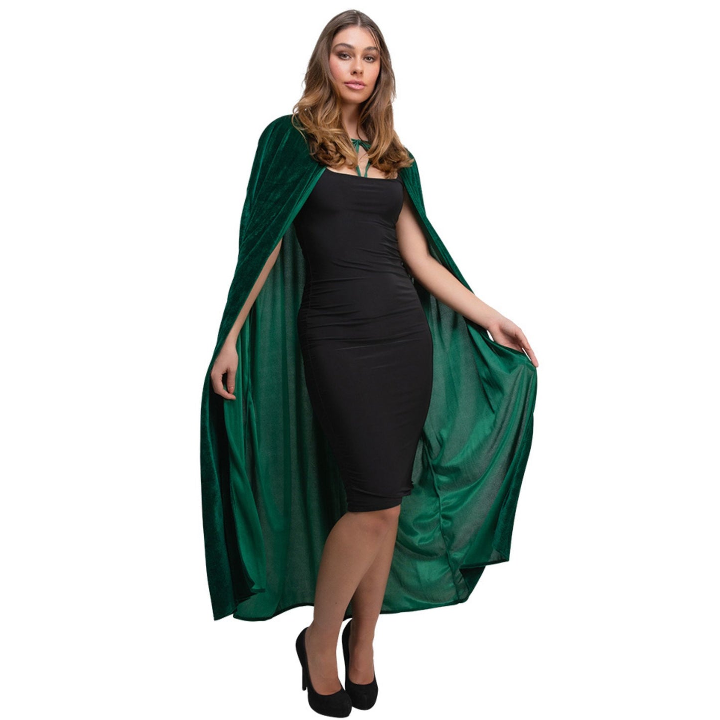 A woman modeling a dark green velvet cape over a black dress, standing against a plain white background.