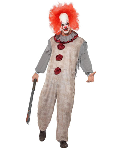 A person modeling a horror clown costume against a plain white background, holding a toy knife. The costume includes a distressed beige jumpsuit with red flower accents, a gray ruffled collar and sleeves, a red wig, and a white face mask with red clown makeup.