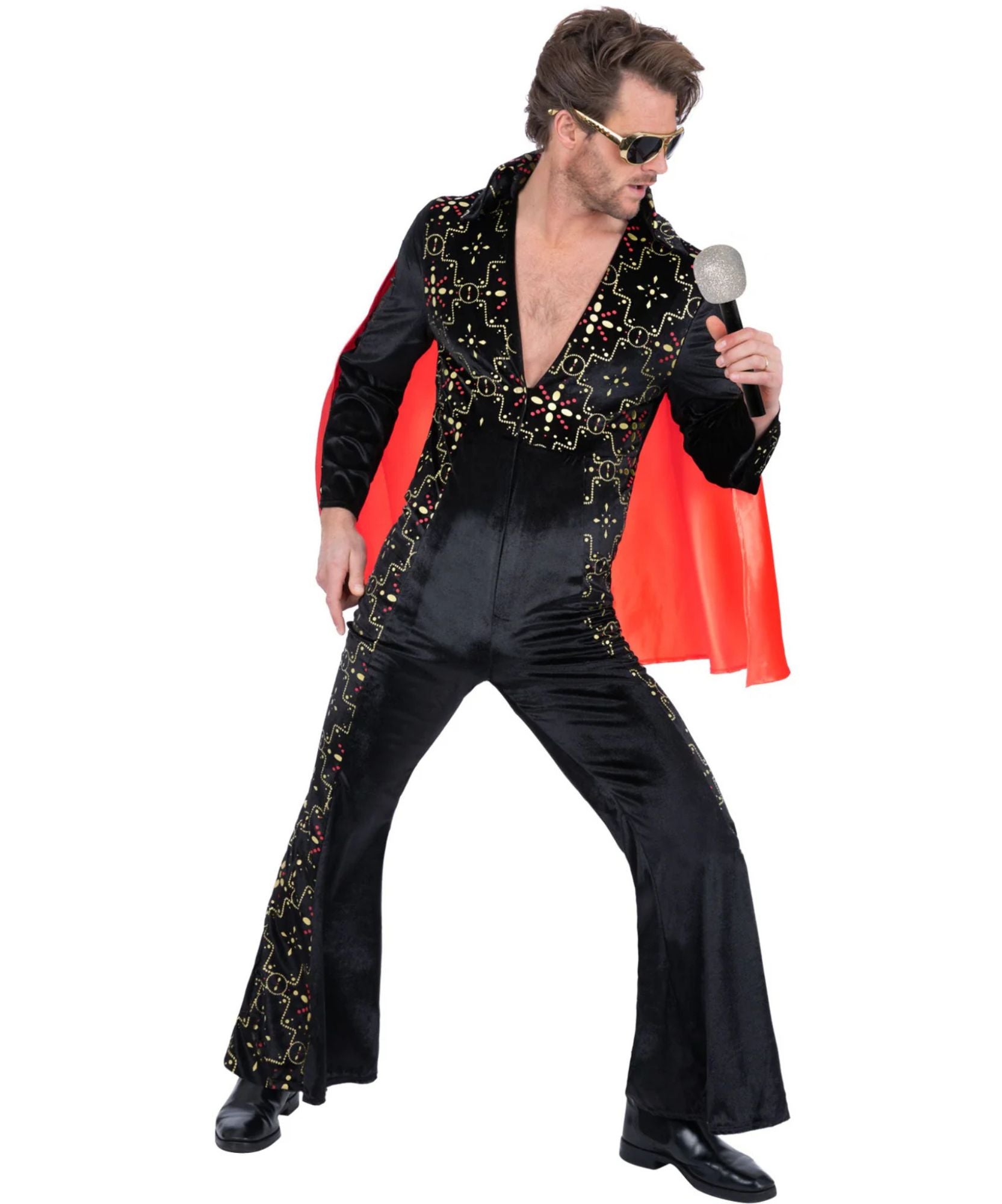 A man modeling a black Elvis-style costume jumpsuit with gold sequins, a bright red cape, and gold-framed sunglasses, holding a silver microphone against a plain white background.