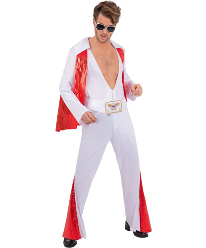 A man modeling a white Elvis Presley-style costume jumpsuit with red mesh side panels, a red draped jacket, and a gold winged belt buckle, against a plain white background.