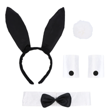 A black and white bunny costume accessory set on a plain white background, including black bunny ears on a headband, a white pom-pom, white cufflinks with black buttons, and a white collar with a black bow tie.
