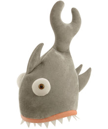 A plush toy shaped like a stylized fish or sea creature, made of gray fabric with a large white eye, pointed gray fins, a curved horn-like fin on top, and a peach-colored mouth border with white teeth.