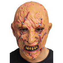A horror-style latex mask with a bald head, stitched skin texture, and an open mouth showing yellowed teeth, worn by a person against a plain white background.