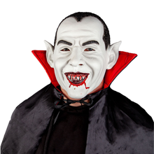 A vampire costume accessory set featuring a white vampire mask with pointed ears, a wide grin showing sharp fangs with red blood details, a red inner collar, and a black cape.