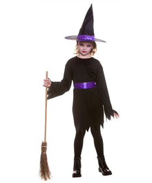 A child modeling a black witch costume with a purple sash and matching pointed black hat with a purple band, holding a small broomstick against a plain white background.