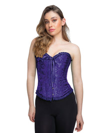 A woman modeling a purple lace corset top with a sweetheart neckline, front tie, and decorative trim, paired with black pants against a plain white background.