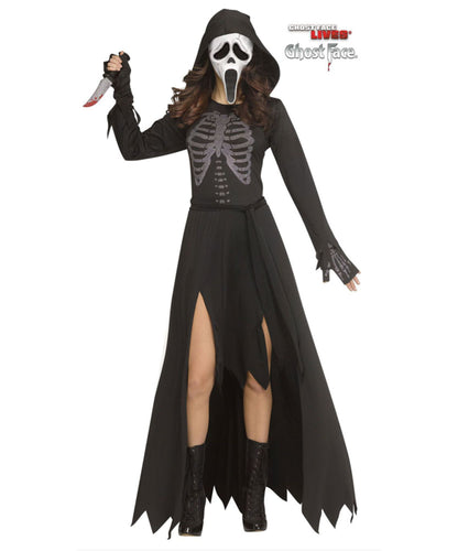 A woman modeling a black Scream-inspired hooded costume dress with a gray skeleton print on the chest, a white mask with black details, black gloves, and black lace-up boots. She holds a knife prop against a plain white background.
